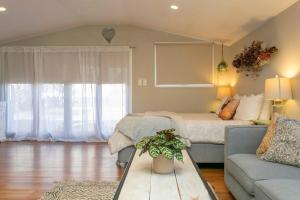a bedroom with a bed and a couch at The French Cottage Great Wifi Private in Taupo