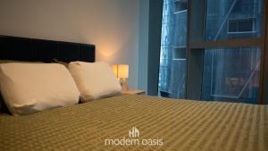 a bedroom with a bed with white pillows and a window at Modern CBD 2BR Free Gym & Pool Walk Everywhere in Melbourne +22 photos