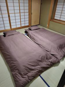 two beds sitting on the floor in a room at はなおか in Takayama