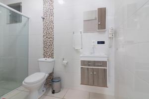 een badkamer met een toilet en een douche bij Pousada Amanhecer do Sul in Penha