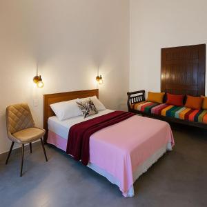 una camera da letto con un letto e una sedia di Vila Caiçara a São Sebastião