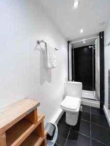 a bathroom with a white toilet and a window at SURF PAD in St Ives, 1 Bed House, 400M to Beach & Harbour in St Ives
