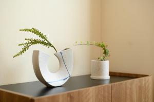 a shelf with two vases and a plant on it at Verdant 601 in Ōdōri