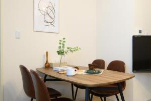 a dining room table with chairs and a tv at Verdant 601 in Ōdōri +36 photos
