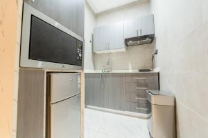 cocina pequeña con TV y nevera en Accra airport/pool, en Otele 14 fotos más