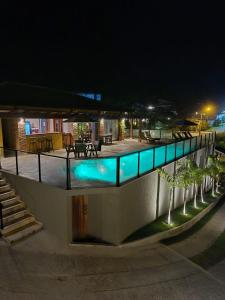 a building with a swimming pool at night at Pousada Búzios Garden in Búzios