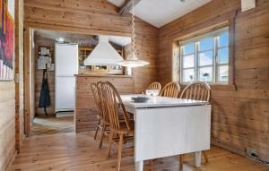 cocina con paredes de madera, mesa y sillas en 3 Bedroom Awesome Home In Slagelse, en Slagelse