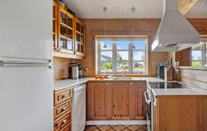 Una cocina con gabinetes de madera y un refrigerador blanco. en 3 Bedroom Awesome Home In Slagelse, en Slagelse