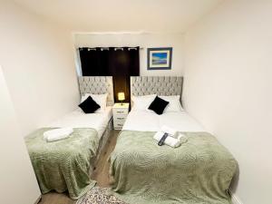 two beds in a small room withskirts at Heathrow Lodge BnB in Harmondsworth