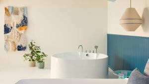 a bathroom with a white sink in a room at Hotel Indigo Albufeira by IHG in Albufeira
