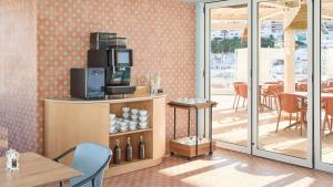 a room with a counter with a microwave and a table at Hotel Indigo Albufeira by IHG in Albufeira