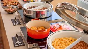 a kitchen counter with food in a pot on a stove at Hotel Indigo Albufeira by IHG in Albufeira