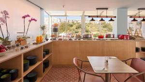 a restaurant with a table and chairs in a room at Hotel Indigo Albufeira by IHG in Albufeira