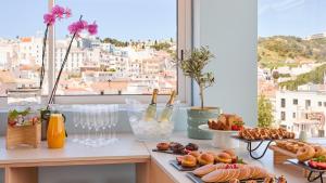 a table with plates of food and a window at Hotel Indigo Albufeira by IHG in Albufeira