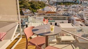 a table with two drinks on a balcony with a view at Hotel Indigo Albufeira by IHG in Albufeira