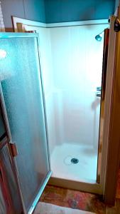 una doccia con una porta in vetro in un bagno di El Hostal Del Valle a El Porvenir