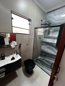 bagno con servizi igienici neri e lavandino di Casa Planalto a Piraju