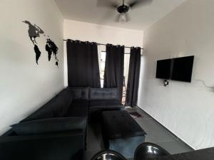 a living room with a couch and a flat screen tv at Casa Planalto in Piraju