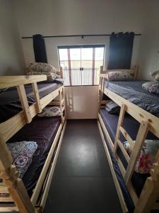 una stanza con tre letti a castello e una finestra di Casa Planalto a Piraju