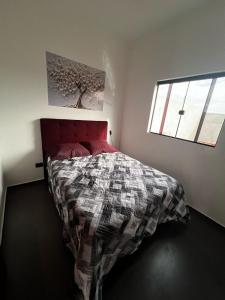 una camera da letto con un letto con un piumone e una finestra di Casa Planalto a Piraju