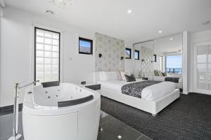 a bedroom with a bed and a bathtub and a bed and a bed at Horizon Deluxe Apartments in Stanley