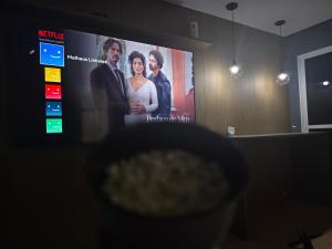 un écran de télévision avec un film projeté dessus dans l'établissement HighView Urban - Modern Rooms, à Rio de Janeiro