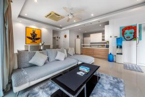 a living room with a couch and a table at 3 Bedroom Pool Villa 5kms from Patong in Ban Kathu