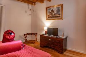 a living room with a red couch and a television at B&B Il Gufo in Erto