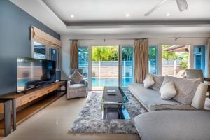 a living room with a couch and a flat screen tv at 3 Bedroom Pool Villa 5kms from Patong in Ban Kathu