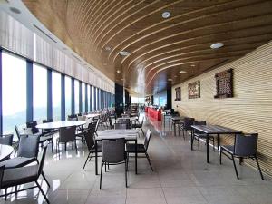 a dining room with tables and chairs and windows at Genting RelaxingColdStudio AT Ion Delemen in Genting Highlands