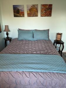 a large bed in a bedroom with two tables at Private Green Cottage near downtown in Asheville