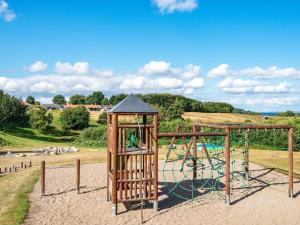 ein Spielplatz mit Schaukel in einem Park in der Unterkunft 5 person holiday home in Aabenraa in Aabenraa + 7 Fotos