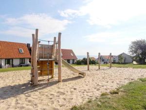 古兹耶姆5 person holiday home on a holiday park in Gudhjem的沙子上的一套木制操场设备