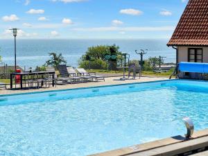 古兹耶姆5 person holiday home on a holiday park in Gudhjem的可以看到海景的游泳池