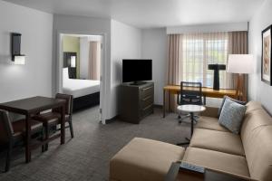 a living room with a couch and a room with a bed at Residence Inn Salt Lake City Sandy in Sandy