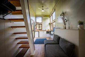 un soggiorno con divano e cucina di Sithuri Tiny House by Tiny Away a Windeyer Altre 8 foto
