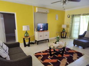 蒙特哥贝3 bedroom with a nice view的带电视、沙发和桌子的客厅