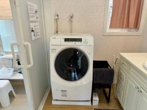 a washing machine in a bathroom with a sink at 23年9月新築のレイクビューアメリカンハウス 和美インターから3分ゴルフ場近郊 in Karuizawa +30 photos