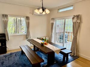 a dining room with a table and a window at 23年9月新築のレイクビューアメリカンハウス 和美インターから3分ゴルフ場近郊 in Karuizawa