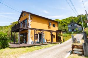 a yellow house on the side of a road at Surf Stay ITOSHIMA in Itoshima