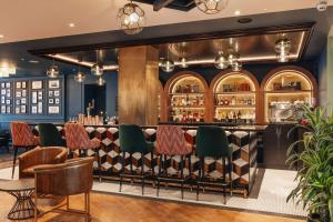 a bar in a restaurant with green chairs at Hotel Indigo London Clerkenwell by IHG in London