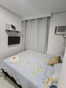 a bedroom with a bed with a comforter on it at Studio CG 4, Campo Grande RJ in Estação Inhoaíba