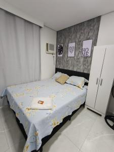 a bedroom with a bed with yellow flowers on it at Studio CG 4, Campo Grande RJ in Estação Inhoaíba