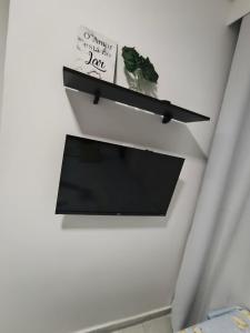 a black shelf on a wall with a plant at Studio CG 4, Campo Grande RJ in Estação Inhoaíba +6 photos