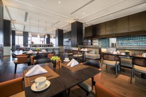 un ristorante con tavoli e sedie e una cucina di 西安曲江芳林苑酒店 a Xi'an