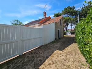 une clôture blanche à côté d'une maison blanche dans l'établissement Charmante Maison Vendéenne à 350m de la Plage avec Cour Ens. et Parking - FR-1-476-180, à La Faute-sur-Mer 2 autres photos
