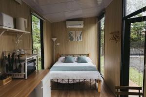 ein Schlafzimmer in einem winzigen Haus mit einem Bett in der Unterkunft Mountain Silhouette Cottage 2 by Tiny Away in Jingmei