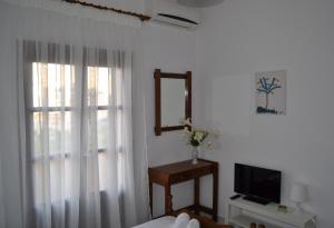 un salon avec une fenêtre et une télévision dans l'établissement Floralia, à Karterados