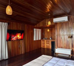 a bedroom with wooden walls and a fire in the fireplace at Cabañas María Isabel, Bacalar in Bacalar
