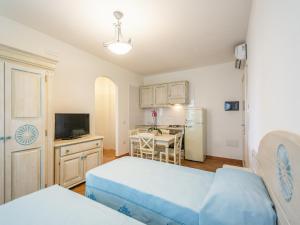 a room with two beds and a kitchen with a table at Apartment in Orosei near Marina di Orosei Beach in Orosei